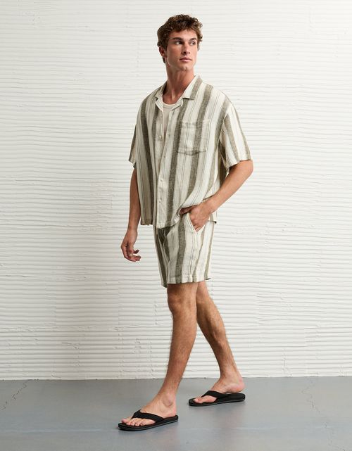 Camisa a rayas con botones de mezcla de lino junto a la piscina